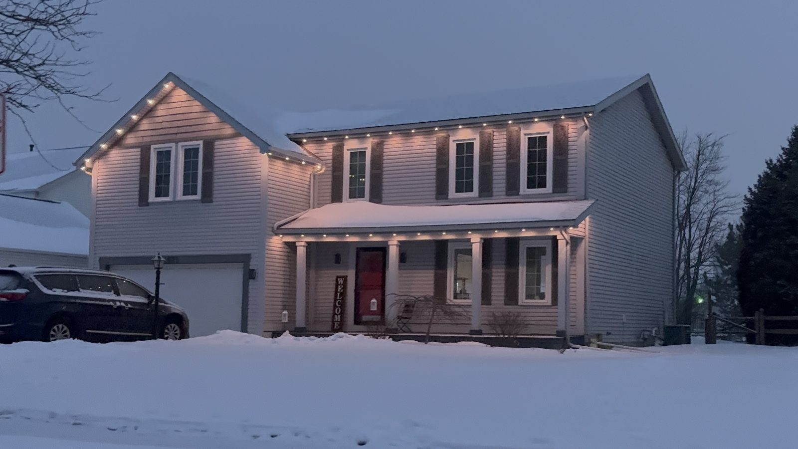 Home roofline glowing in red and green Jellyfish lighting scene during the holiday season