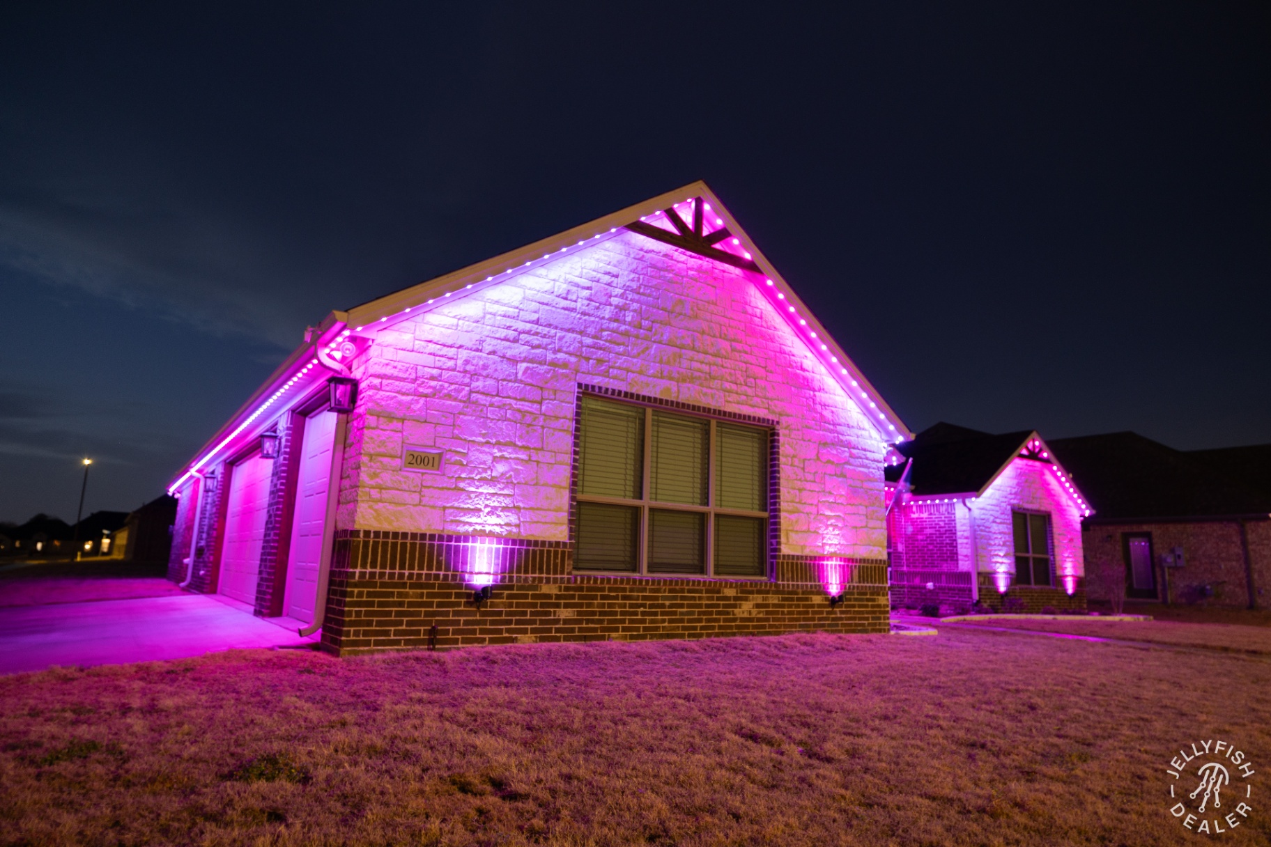 Pink uplights on stone facade