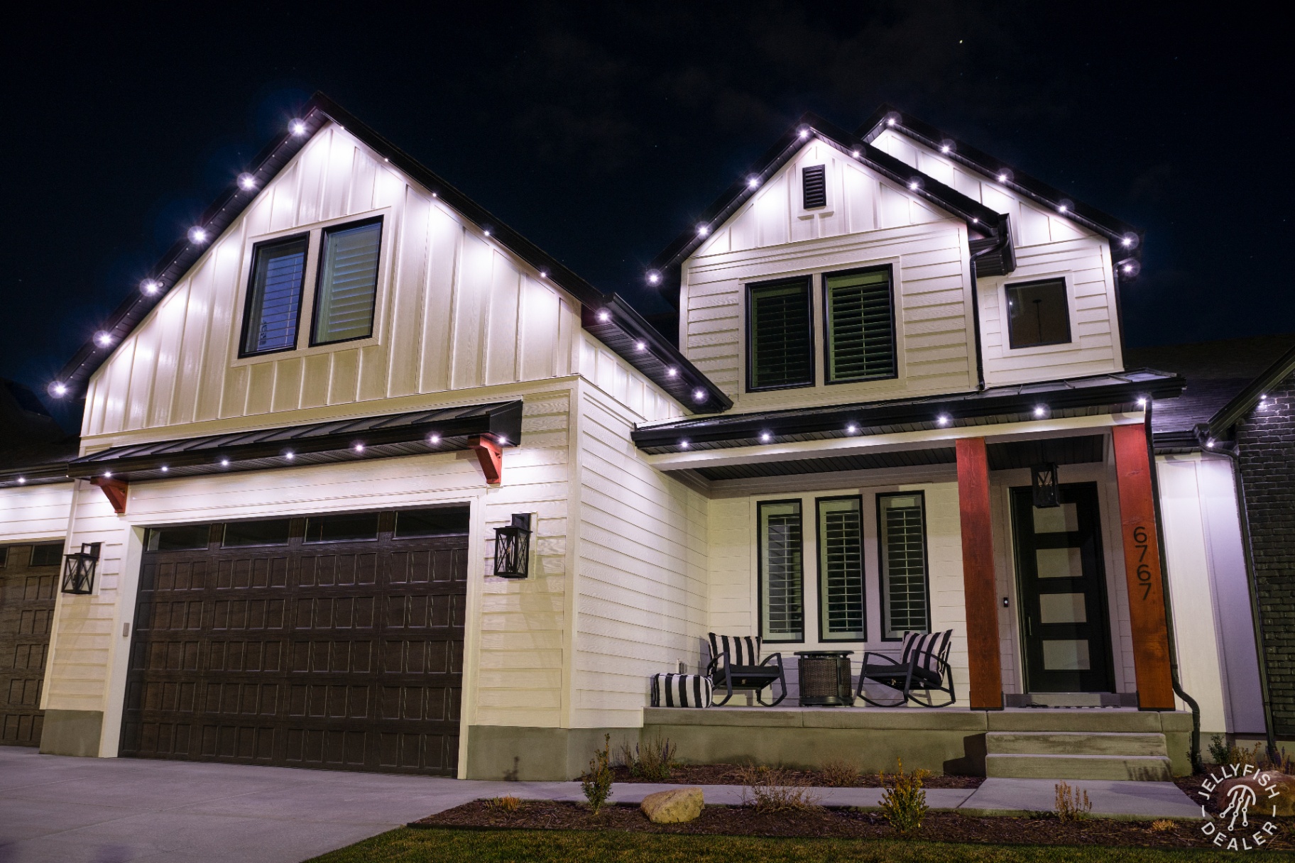 Home decorated with traditional warm white holiday lights along the roofline and shrubs